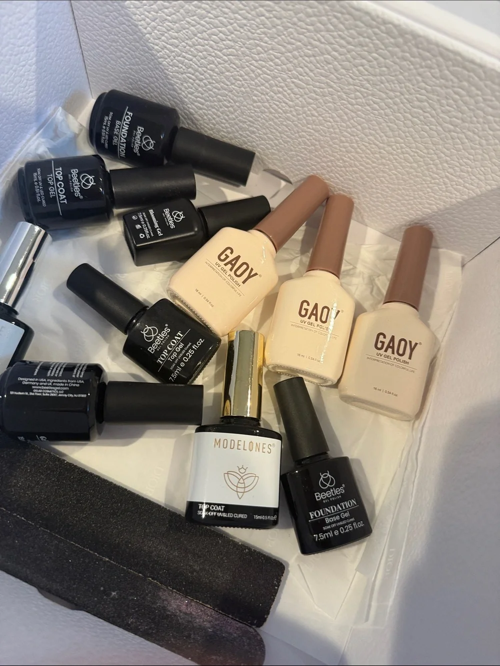Collection of gel, nail polishes. Mostly light neutrals and dark neutrals.